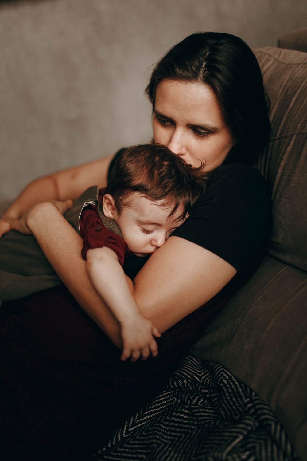 Mère épuisée tenant son bébé endormi contre elle